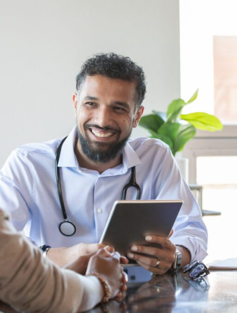 smiling male doctor holding a tablet